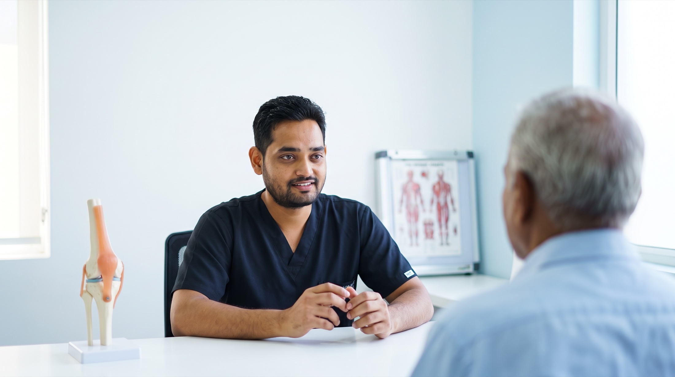 Dr. Arun Dev talking with a patient about neck pain